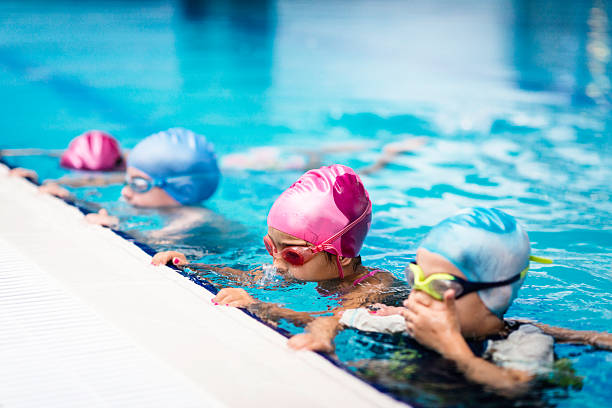 Young swimmer with an adult instructor during a one-on-one lesson in the pool